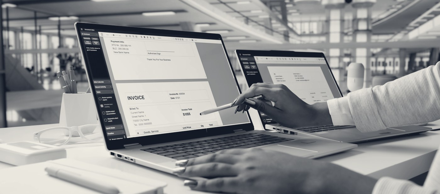 An invoice open on a laptop being matched by hand